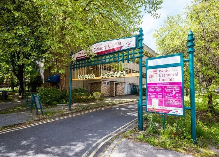 The entrance to ParkSafe Cathedral Quarter car park in Derby, with teal gates and clear pink signage