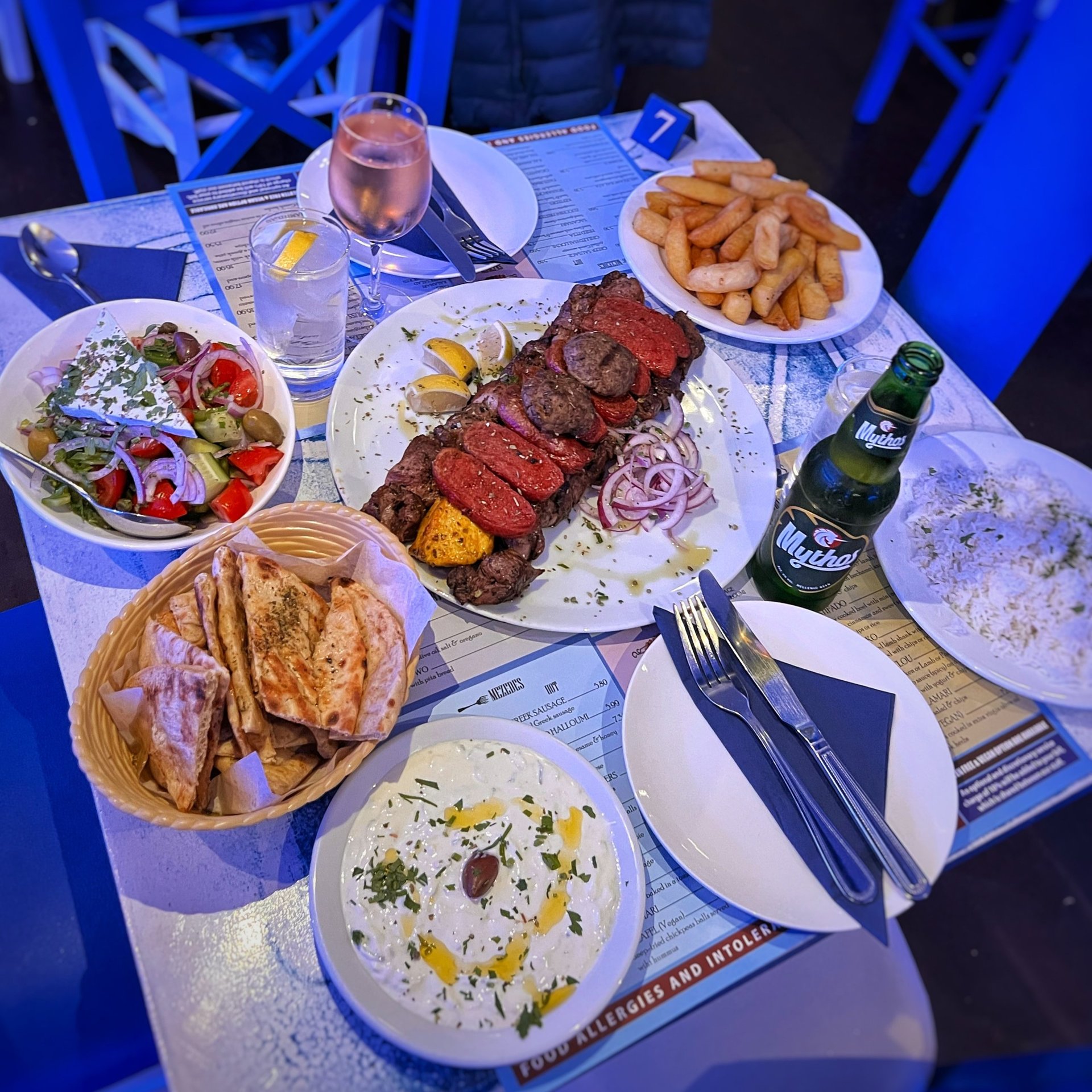 A full table at Zorba The Greek laid with Greek dishes for a celebration