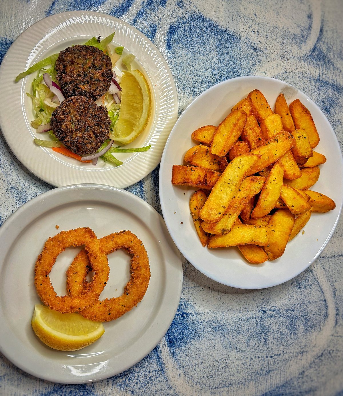 Round three of Zorba's meze — zucchini fritters, fried calamari rings and chips with lemon